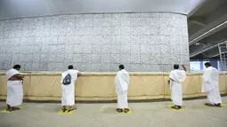 Jemaah haji melangsungkan lontar jumrah dengan menerapkan jaga jarak aman untuk menghindari penularan COVID-19 di Mina, Arab Saudi, Jumat (31/7/2020). Ritual melempar batu ke pilar ini menjadi simbol merajam setan. (Saudi Ministry of Media via AP)