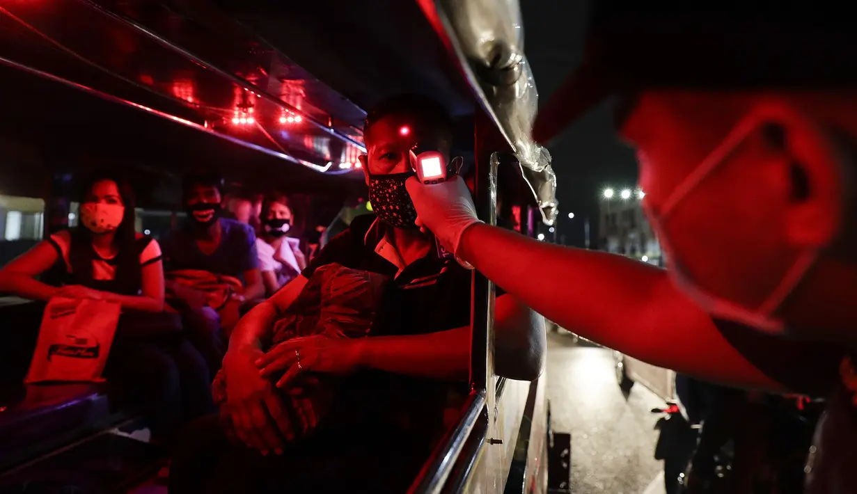 Polisi memeriksa suhu tubuh penumpang dalam jeepney di pos pemeriksaan virus corona COVID-19 di Manila, Filipina, Senin (16/3/2020). Polisi beserta petugas lalu lintas dan petugas desa melakukan pengecekan suhu tubuh warga untuk mencegah penyebaran virus corona COVID-19. (AP Photo/Aaron Favila)