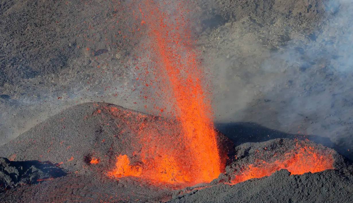 Semburan lava pijar dari Gunung Piton de la Fournaise, La Reunion, Prancis, Rabi (1/2). Gunung tersebut kembali meletus pada Selasa (31/1) malam waktu setempat dan terus menyemburkan lava pijar. (AFP Photo/Richard Bouhet)