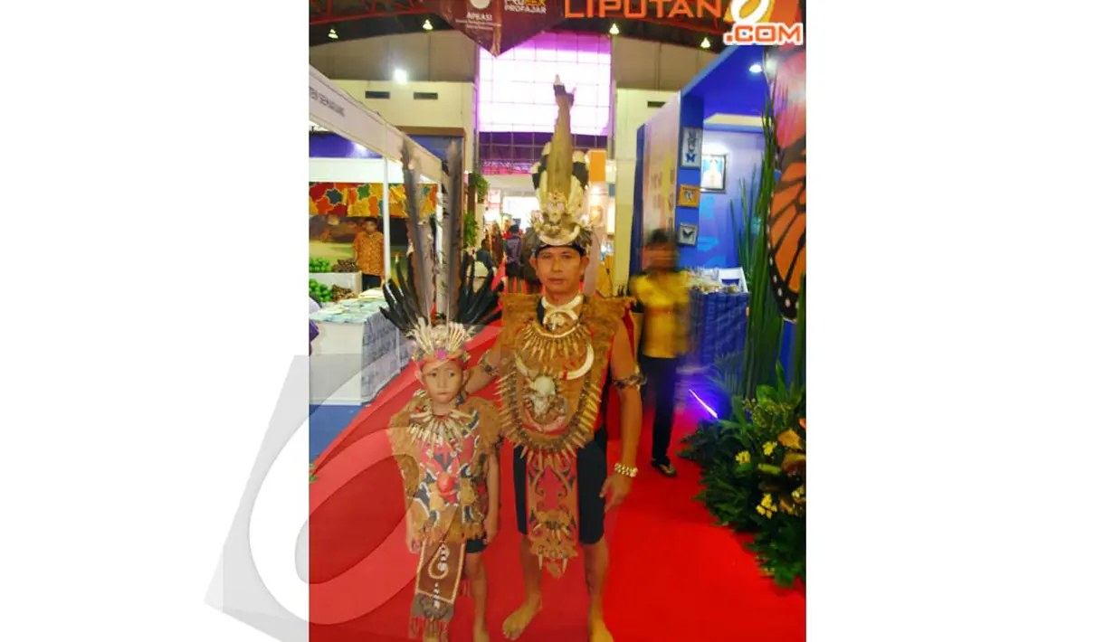 Salah satu peserta pameran tampak bersama dengan seorang bocah mengenakan pakaian daerahnya untuk menarik pengunjung, JIExpo, Kemayoran, Senin (14/04/2014) (Liputan6.com/Miftahul Hayat).