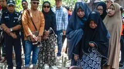 Bibi (kanan bawah) dari penyelam Syachrul Anto yang meninggal dunia kala melakukan evakuasi jatuhnya pesawat Lion Air PK-LQP, berdoa saat pemakaman di Surabaya, Jawa Timur, Sabtu (3/11). Syachrul Anto meninggal karena dekompresi. (JUNI KRISWANTO/AFP)