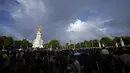 Orang-orang berkumpul di luar Istana Buckingham saat pelangi ganda muncul di atas langit London, Kamis, 8 September 2022. Dikutip dari People, pelangi tersebut muncul sesaat sebelum kematian Sang Ratu diumumkan ke penjuru negeri. Fenomena ini pun mencuri perhatian publik. (AP Photo/Frank Augstein)