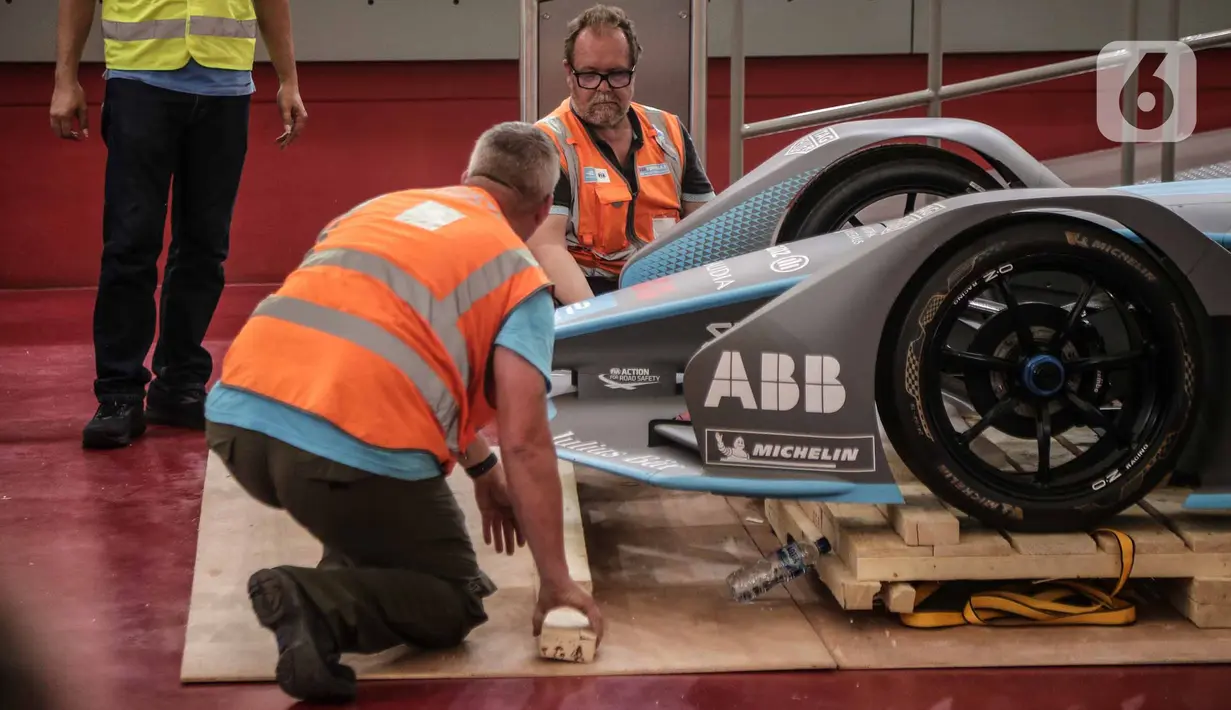 Panitia membuka kemasan replika mobil Formula E untuk kali pertama di Stadion Balap Sepeda Velodrome, Rawamangun, Jakarta Timur, pada Kamis (26/5/2022). Ini merupakan replika salah satu mobil Formula E yang akan mengaspal di Sirkuit Ancol pada 4 Juni mendatang. (Liputan6.com/Faizal Fanani)