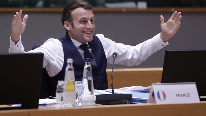 Presiden Prancis Emmanuel Macron memberi isyarat setelah sesi negosiasi sepanjang malam di KTT Uni Eropa di Brussels (11/12/2020). Istana kepresidenan Prancis hanya memberikan keterangan singkat. Dijelaskan bahwa Presiden Macron langsung melakukan tes ketika ada gejala. (AP Photo/Olivier Hoslet)