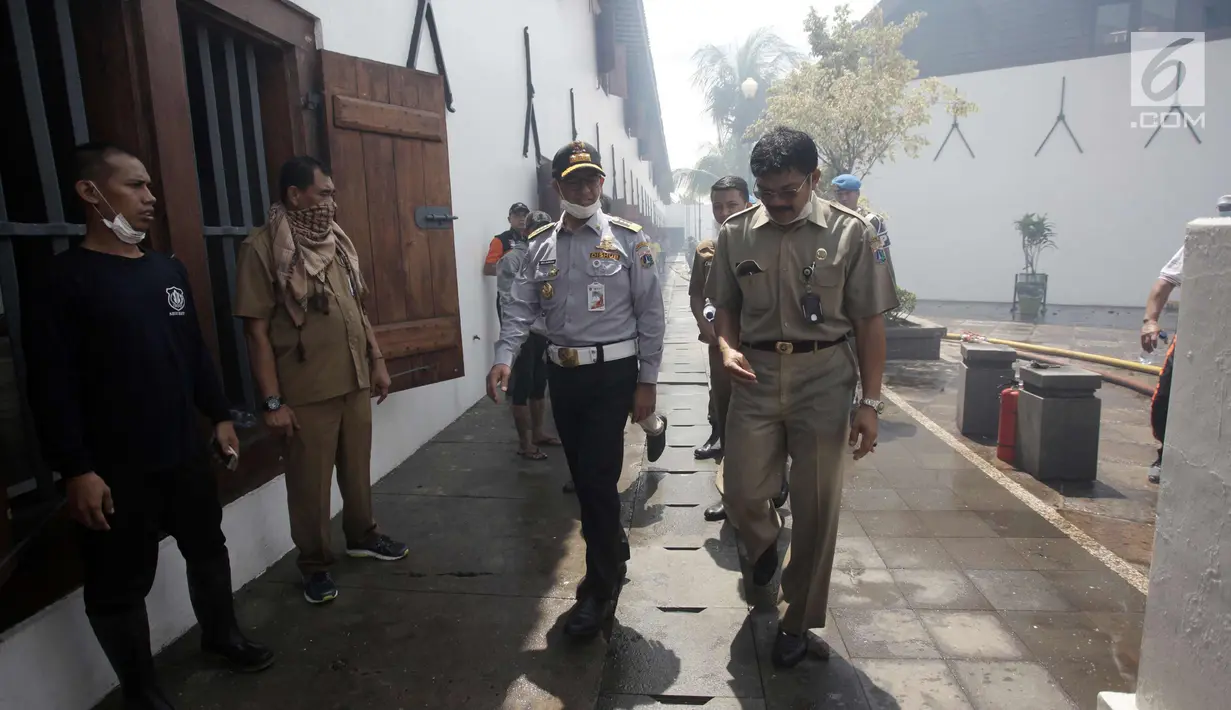 Gubernur DKI Jakarta Anies Baswedan saat meninjau lokasi kebakaran Museum Bahari, di Jalan Pasar Ikan, Penjaringan, Jakarta Utara, Selasa (16/1). Anies datang menggenakan pakaian Dishub ditemani pejabat Pemprov DKI Jakarta. (Liputan6.com/Arya Manggala)