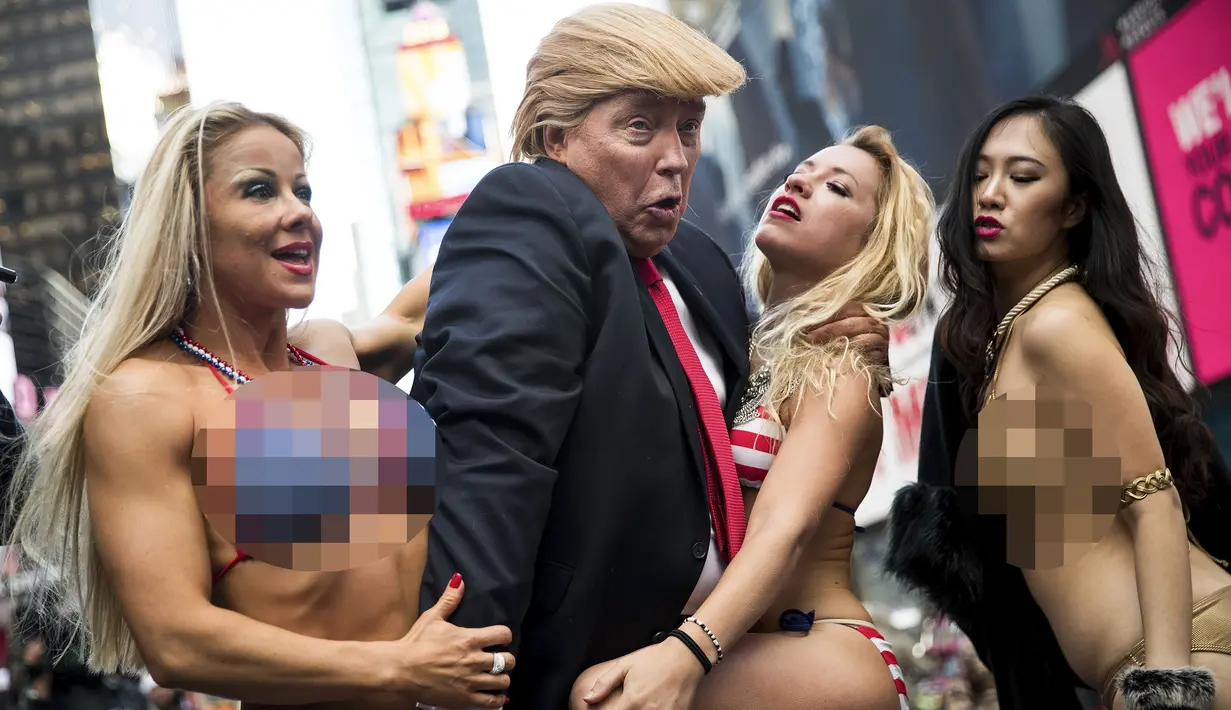 Seorang seniman berpenampilan seperti Donald Trump meraba-raba wanita seksi berbikini saat berada di depan Trump Tower di New York, (25/10). Aksi ini dilakukan oleh seniman Alison Jackson. (AFP Photo/Drew Angerer/Getty Images)