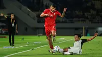 Bek Persija Jakarta, Firza Andika, saat berusaha menekel bola dari penguasaan gelandang asing Borneo FC, Berguinho, pada laga semifinal Piala Presiden 2024 di Stadion Manahan, Solo, Selasa (30/7/2024). (Bola.com/Radifa Arsa)