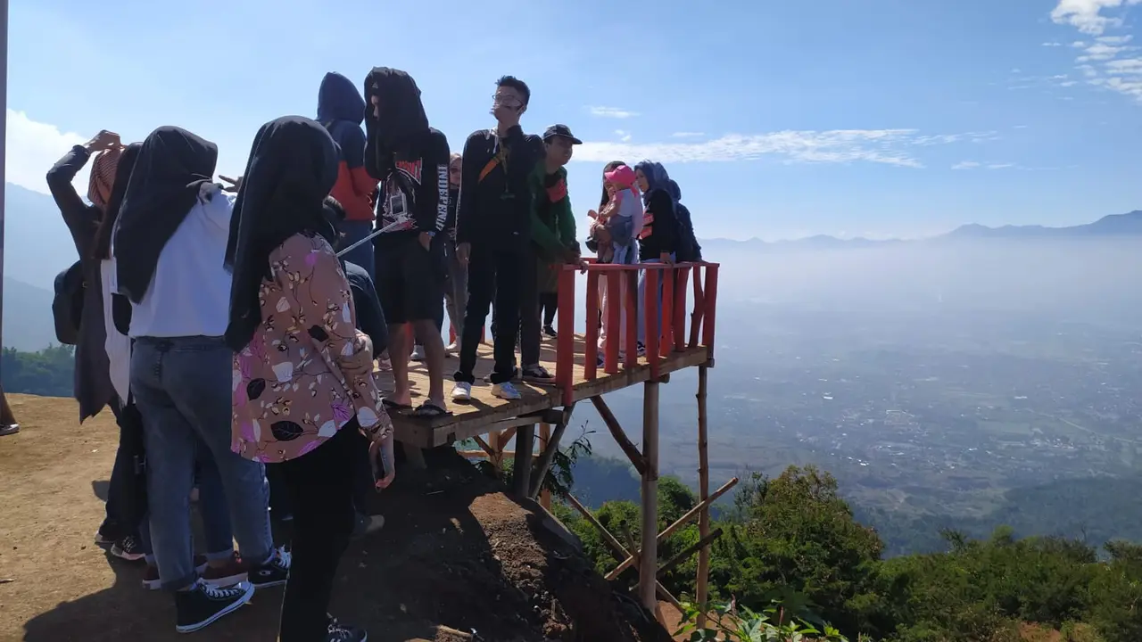 Beberapa pengunjung tengah menikmati view topping awan dan pesona Garut dari ketinggian di Bukit Intan Dewata, Garut, Jawa Barat.