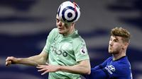 Striker Chelsea, Timo Werner, duel udara dengan pemain  Everton, Michael Keane, pada laga Liga Inggris di Stadion Stamford Bridge, Senin (8/3/2021). Chelsea menang dengan skor 2-0. (Glyn Kirk/Pool via AP)