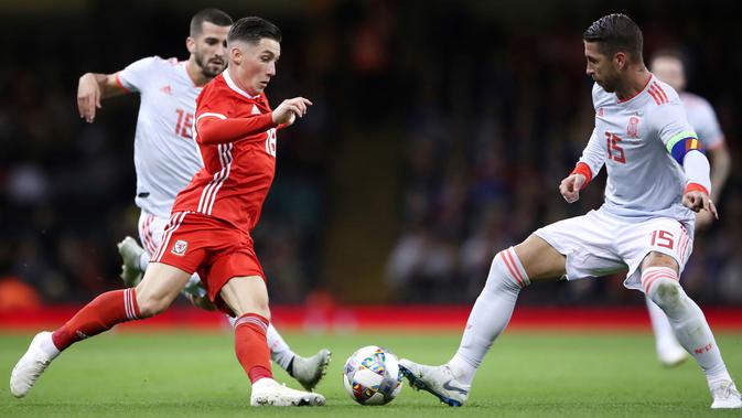 Gelandang Wales, Harry Wilson berusaha melewati bek Spanyol, Sergio Ramos saat bertanding pada uji coba internasional di Stadion Principality, Cardiff, Inggris (11/10). Spanyol menang telak 4-1 atas Wales. (AP Photo/Nick Potts)
