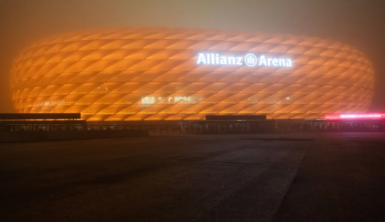 Allianz Arena, markas dari FC Bayern Munchen, diterangi warna oranye untuk kampanye "Orange the World" di Munich, Jerman, Senin (25/11/2019). Cahaya berwarna oranye untuk melambangkan partisipasi mendukung penghapusan kekerasan terhadap perempuan. (Lino Mirgeler/dpa/AFP)