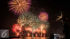 Kembang api menghiasi perayaan malam pergantian tahun di Pantai Lagoon, Ancol, Jakarta (1/1). Warga ibukota memadati kawasan Ancol sebagai pusat perayaan malam pergantian tahun baru dengan menikmati atraksi kembang api. (Liputan6.com/Gempur M. Surya)