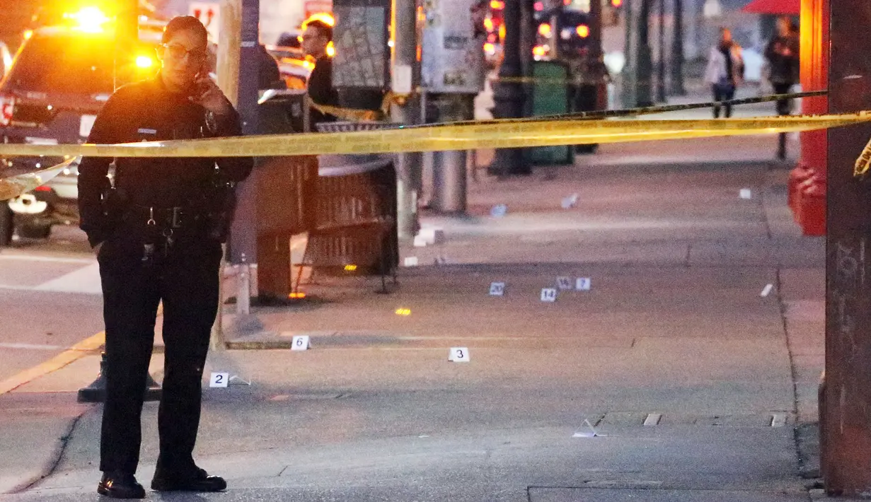 Seorang polisi wanita berjaga di lokasi penikaman yang menewaskan dua orang di Chinatwown, Los Angeles, AS (26/1). Hingga saat ini, polisi dibantu anjing pelacak sedang berusahan mencari pelaku yang berhasil melarikan diri.  (AP Photo / Reed Saxon)