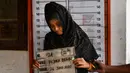 Pengungsi etnis Rohingya memegang papan berisi identitasnya saat pendataan di pusat penampungan sementara bekas kantor Imigrasi Punteuet di Lhokseumawe, Aceh Utara (26/6/2020). (AFP Photo/CHAIDEER MAHYUDDIN)