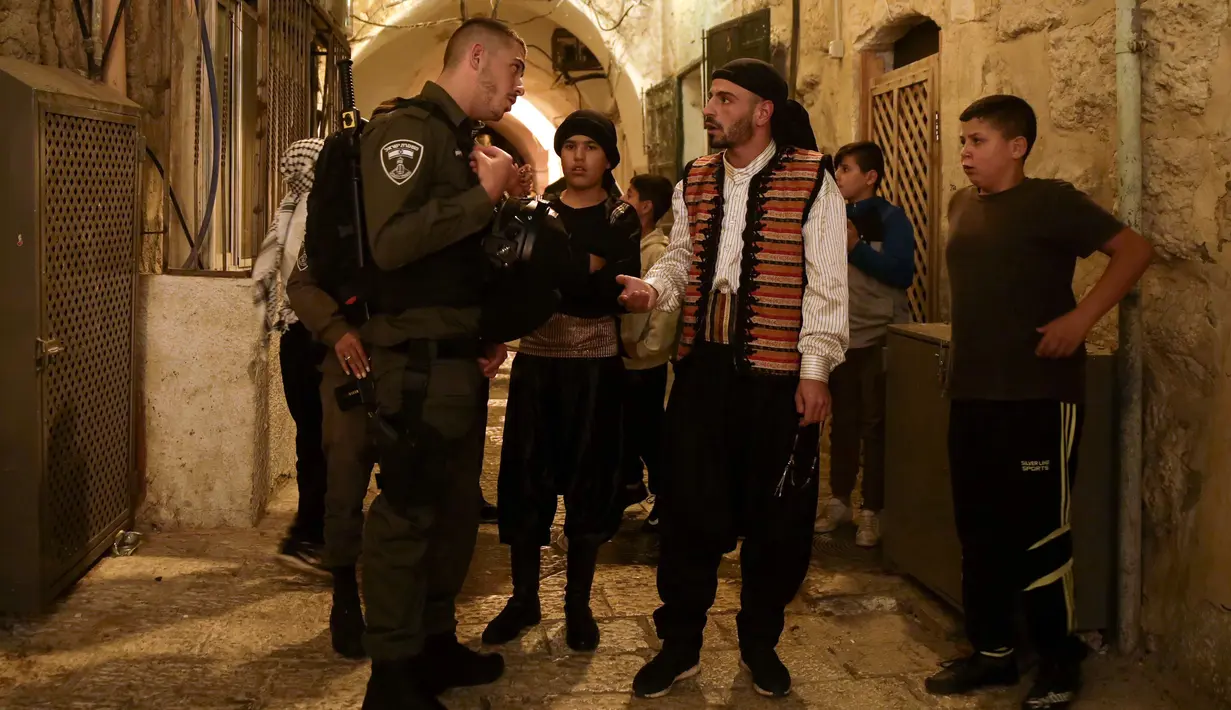 Kelompok pemuda Palestina dihentikan polisi perbatasan Israel ketika membangunkan kaum muslim untuk sahur di Kota Tua Yerusalem, Selasa (5/6). Membangunkan sahur atau Musaharati sudah menjadi tradisi yang dilakukan secara turun-temurun (AP/Mahmoud Illean)