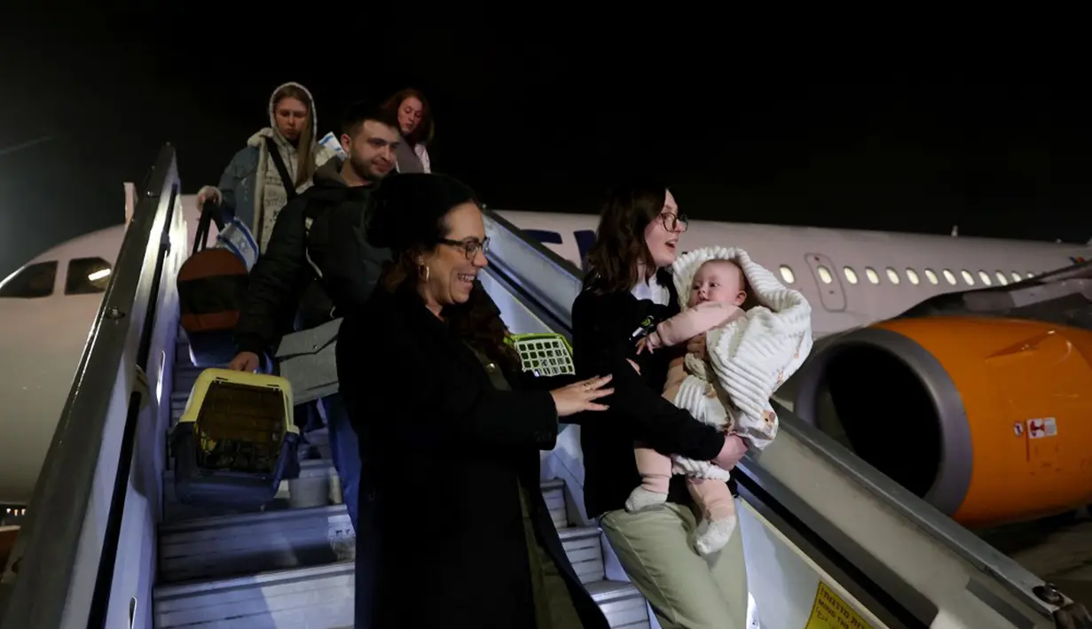 Pengungsi Yahudi Ukraina dan imigran baru yang melarikan diri dari perang di negara mereka turun dari pesawat setibanya di Bandara Ben Gurion, Tel Aviv, Israel, 22 Desember 2022. Sebanyak 100 orang Yahudi Ukraina tiba di Israel, termasuk beberapa penumpang yang terbaring di tempat tidur dan dalam kondisi sakit. (GIL COHEN-MAGEN/AFP)