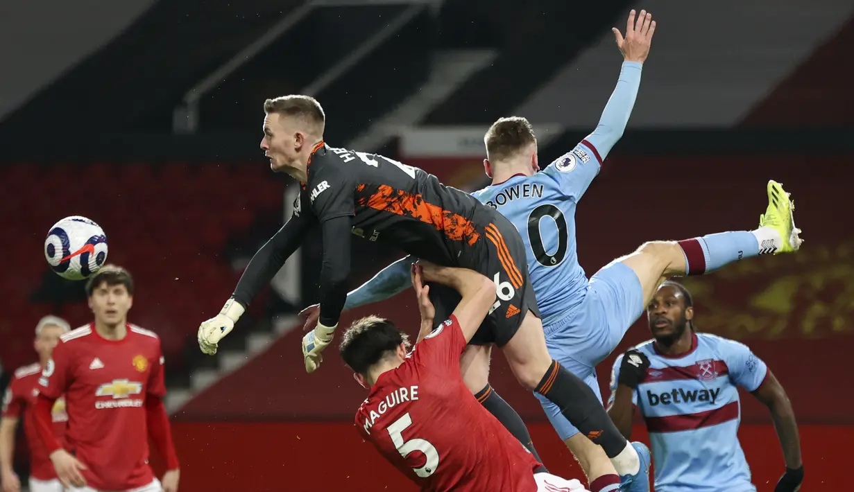 Kiper Manchester United, Dean Henderson memukul bola saat pekan 29 Liga Inggris 2020-2021 kontra West Ham di Old Trafford, Senin dinihari WIB (15/3/2021). Manchester United atau MU berhasil mencuri poin penuh usai kalahkan West Ham 1-0. (AP Photo/Clive Brunskill,Pool)