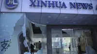 Pengunjuk rasa membakar stasiun metro dan merusak bangunan, termasuk kantor berita resmi China, Xinhua. (AP/Kin Cheung)