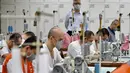 Para tahanan menggunakan mesin jahit saat membuat masker di Penjara Taipei di Kota Taoyuan, Taiwan utara (10/3/2020). Taiwan berhasil mempertahankan jumlah kasus virus corona yang dikonfirmasi menjadi 45 dan satu kematian. (AFP/Sam Yeh)