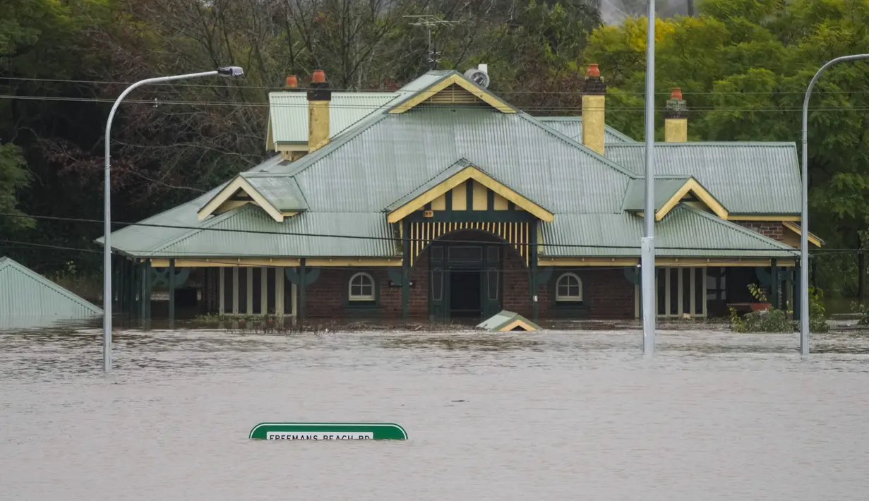 Sebuah bangunan dibanjiri air di ujung Jembatan Windsor di Windsor di pinggiran Sydney, Australia, Selasa (5/6/2022). Ratusan rumah terendam di dalam dan sekitar kota terbesar Australia itu dalam keadaan darurat banjir yang berdampak pada 50.000 orang, kata para pejabat. (AP Photo/Mark Baker)