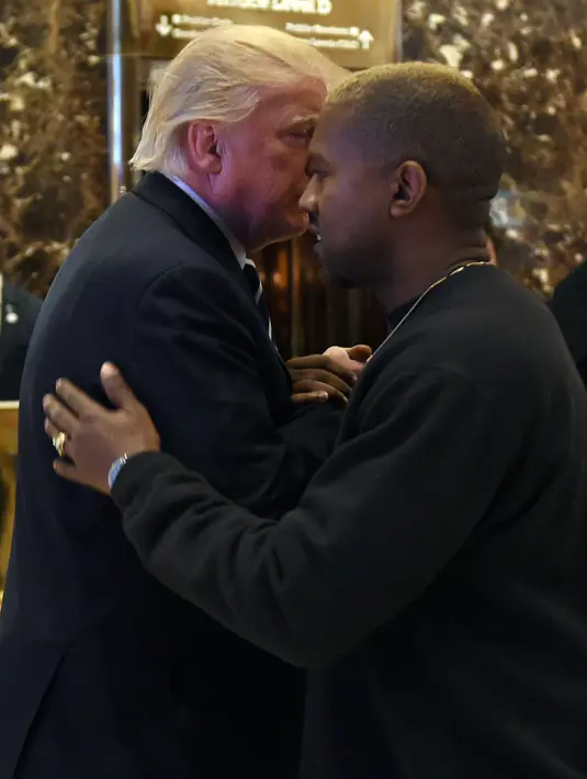 Penyanyi rap Kanye West memeluk Presiden AS terpilih, Donald Trump usai melakukan pertemuan di Trump Tower, New York, Selasa (13/12). Menurut West, ia ingin membicarakan masalah-masalah multikultural dengan Trump. (TIMOTHY A. CLARY/AFP)