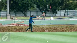 Pekerja mengecek rumput lapangan latihan timnas Indonesia di Kompleks Gelora Bung Karno, Senayan, Jakarta, Rabu (10/5). Pemerintah melakukan renovasi total kawasan Gelora Bung Karno guna menyambut Asian Games 2018. (Liputan6.com/Gempur M Surya)