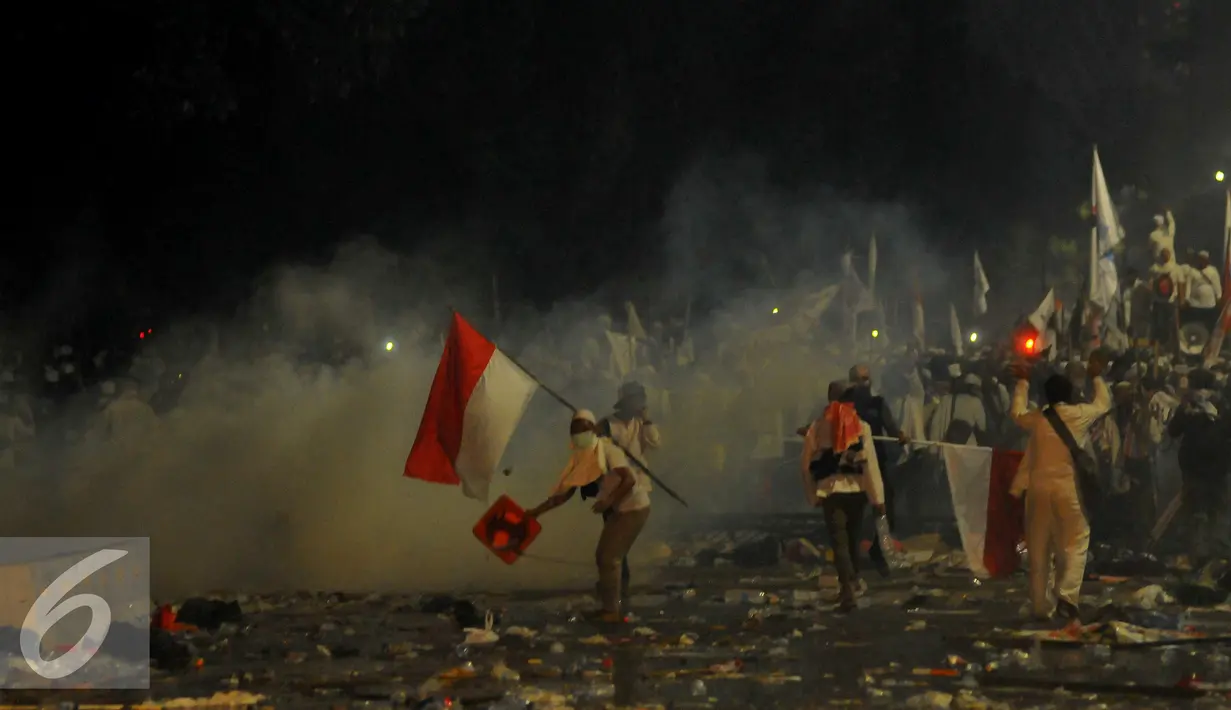 Suasana rusuh saat terjadi bentrokan antara petugas dengan Aksi Damai 4 November, Jakarta, Jumat (4/11). Belum diketahui apa yang menyebabkan terjadinya bentrokan dari aksi yang awalnya damai ini. (Liputan6.com/Angga Yuniar)