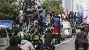 Mahasiswa menaiki sejumlah truk saat konvoi menuju Gedung DPR/MPR, Jakarta, Kamis (8/10/2020). Mahasiswa ini rencananya akan menggelar aksi menolak UU Cipta Kerja. (Liputan6.com/Johan Tallo)