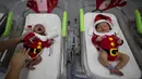Perawat merawat bayi yang baru lahir di Rumah Sakit Synphaet, Bangkok, Thailand, Selasa (24/12/2019). Bayi-bayi tersebut dipakaikan kostum sinterklas untuk menyambut Hari Raya Natal. (AP Photo/Sakchai Lalit)