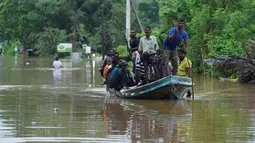 Warga Sri Lanka menggunakan perahu untuk melewati banjir akibat hujan deras di Pugoda, Senin (16/5). Pemerintah telah mengerahkan petugas untuk mengevakuasi warga yang tinggal di lereng atau di daerah yang dilanda banjir. (Ishara S.KODIKARA/AFP)