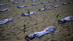 Gambar dari total 120 kain kafan yang diwarnai dengan cat merah dan ditandai dengan bendera Palestina yang dipasang oleh LSM Rio de Paz di Pantai Copacabana di Rio de Janeiro, Brasil, Jumat (3/11/2023). (Carl DE SOUZA / AFP)