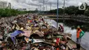 Warga memilah sampah sisa banjir yang dikumpulkan dari sepanjang Kali Cengkareng, Jakarta Barat, Kamis (9/1/2020). Tumpukan sampah di sepanjang bantaran kali dan rumah-rumah warga terlihat setelah banjir yang melanda sejumlah kawasan Jakarta mulai surut. (Liputan6.com/Johan Tallo)