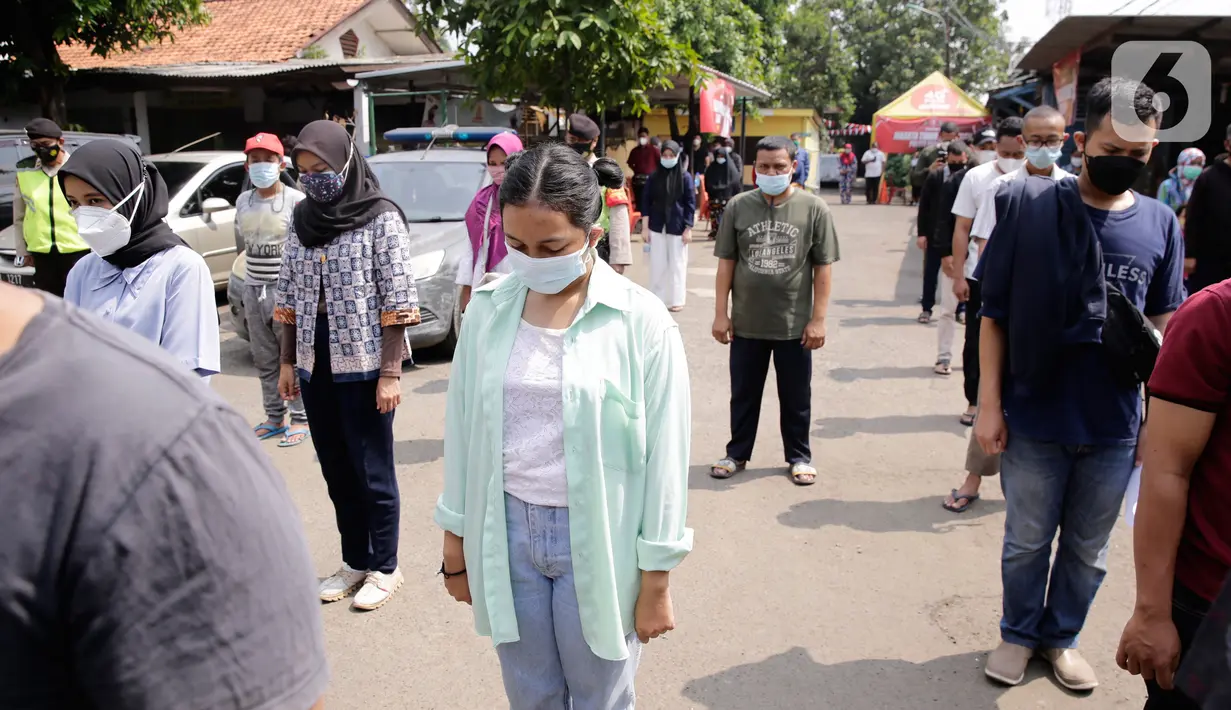 Ratusan masyarakat yang mengikuti vaksin Covid-19 berdiri mengheningkan cipta sejenak memperingati HUT ke-76 RI di Jakarta, Selasa (17/8/2021). Hal tersebut dilakukan untuk mengenang jasa para pahlawan dalam memperjuangkan Kemerdekan Republik Indonesia. (Liputan6.com/Angga Yuniar)