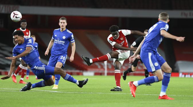 Gelandang Arsenal, Bukayo Saka melakukan tembakan dari kawalan pemain Leicester City pada pertandingan lanjutan Liga Inggris di Stadion Emirates di London, Inggris, Minggu (25/10/2020). Leicester City menang 1-0 atas Arsenal. (AP Photo/Ian Walton,Pool)