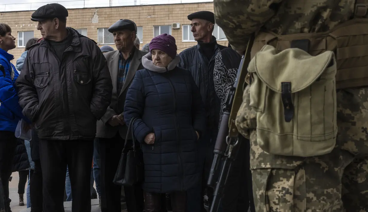 Pengungsi mengantre di luar Departemen Distrik Layanan Migrasi Negara untuk menerima makanan dan tempat tidur, di Brovary, di pinggiran Kiev, Ukraina, Selasa, 29 Maret 2022. Invasi Rusia ke Ukraina yang dimulai pada 24 Feberuari 2022 masih berlangsung hingga hari ini. (AP Photo/Rodrigo Abd)