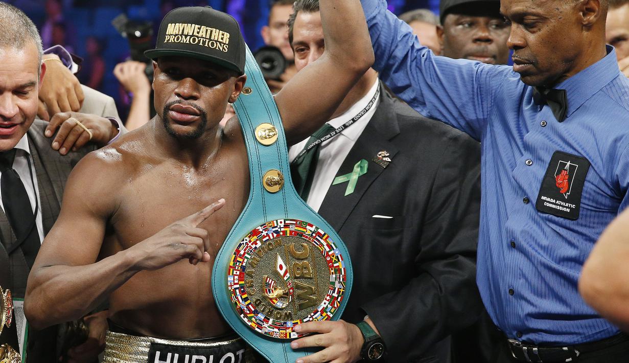 Wasit Kenny Bayless mengangkat tangan Mayweather Jr. untuk menandakan ia keluar sebagai juara megaduel lawan Pacquiao (AP Photo/John Locher)