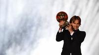 Gelandang Real Madrid asal Kroasia, Luka Modric, menunjukan trofi saat malam penghargaan Ballon d'Or di Paris, Senin (3/12). Dirinya berhasil meraih gelar Ballon d'Or. (AFP/Franck Fife)