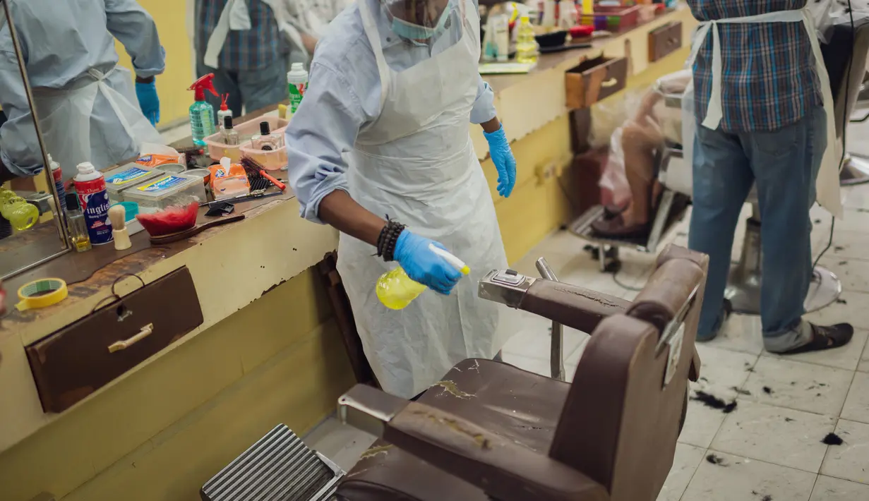 Seorang barber menyemprotkan disinfektan ke kursi di sebuah tempat pangkas rambut di Kuala Lumpur, 10 Juni 2020. Setelah hampir tiga bulan masa lockdown, pemerintah Malaysia melakukan pelonggaran untuk menghidupkan kembali perekonomian yang sempat terpukul akibat pandemi Covid-19. (Xinhua/Zhu Wei)