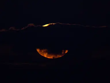 Pemadangan saat bulan terbenam di balik awan di laut Mediterania di lepas pantai Hadera, Israel, Rabu (31/1). (AP Photo / Ariel Schalit)