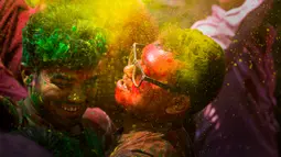Orang-orang menari dan melempar bubuk berwarna saat Festival Holi di Gauhati, India, Selasa (10/3/2020). Festival Holi menandai datangnya musim semi di India. (AP Photo/Anupam Nath)