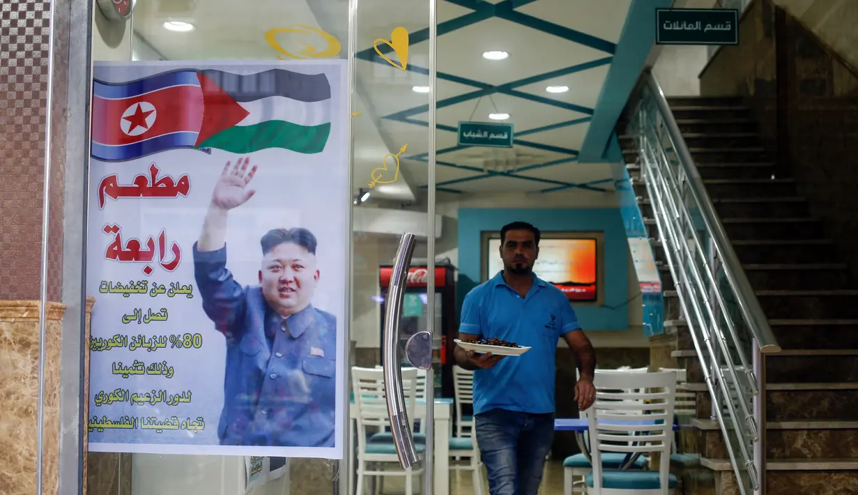 Pelayan menyajikan makanan di restoran Rabaa, Gaza, Minggu (17/12). Restoran Rabaa menawarkan diskon kepada warga Korea Utara sebagai ucapan terima kasih karena Kim Jong-un mengecam AS atas Yerusalem sebagai Ibu Kota Israel. (MOHAMMED ABED/AFP)