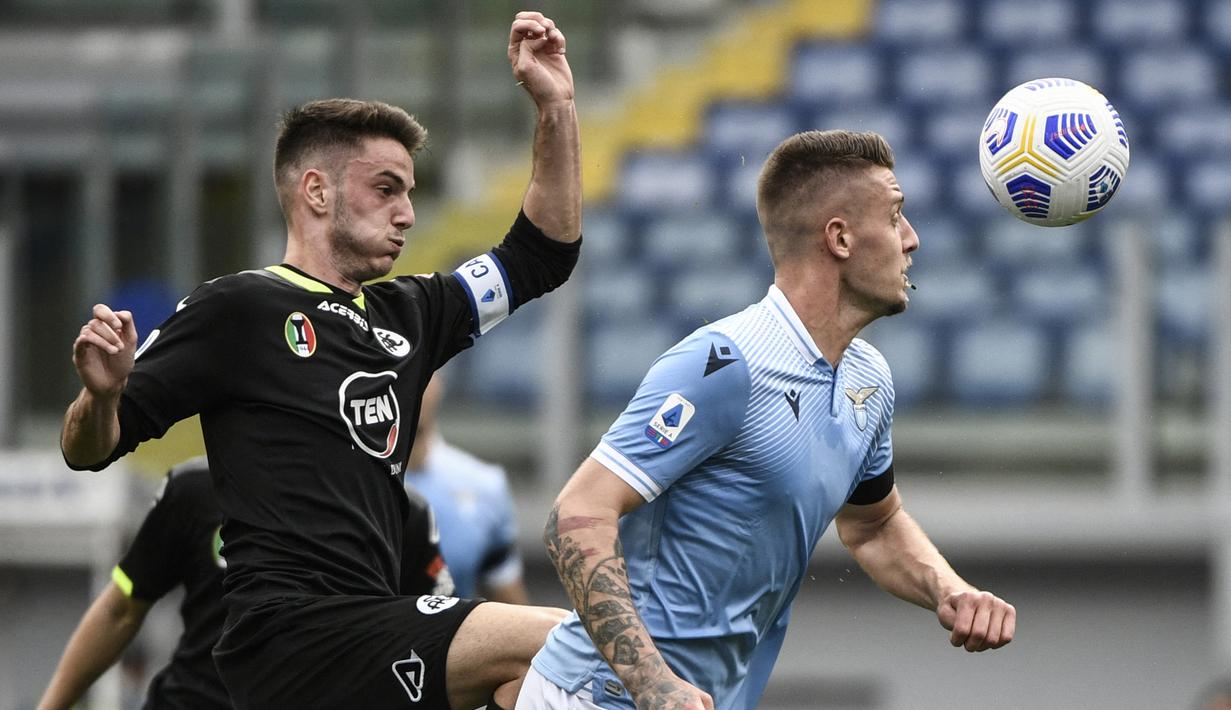 Giulio Maggiore (kiri). Gelandang Italia berusia 24 tahun ini telah 6 musim memperkuat Spezia sejak berlaga di Serie B pada awal musim 2016/2017 usai dipromosikan dari tim U-19 dan akhirnya prmosi ke Serie A sejak musim 2020/2021. Jabatan kapten tim telah disandangnya sejak pertengahan musim 2019/2020 saat masih berlaga di Serie B. Berkat kepemimpinannya musim 2021/2022, Spezia berhasil lolos dari jurang degradasi. (AFP/Filippo Monteforte)