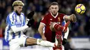 Aksi pemain Liverpool, Jordan Henderson (kanan) menghalau bola dari kaki pemain Huddersfield Town, Philip Billing pada lanjutan Premier League di John Smith's Stadium, Huddersfield, (30/1/2018). Liverpool menang 3-0. (Martin Rickett/PA via AP)