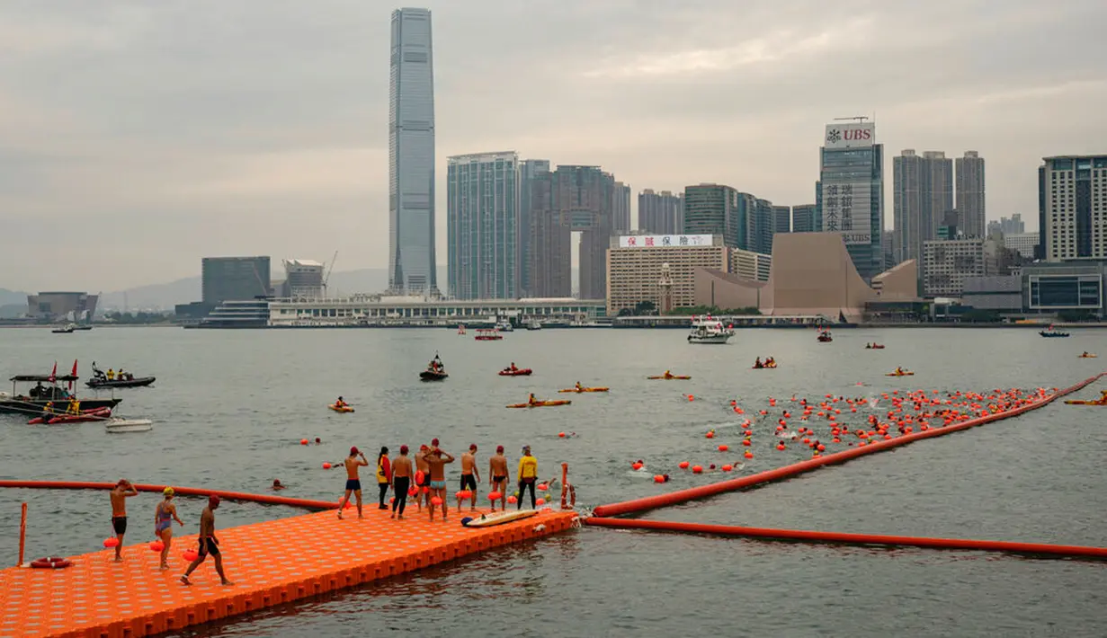 Seorang perenang bersiap di garis start jelang lomba renang tahunan di Pelabuhan Victoria, Hong Kong, Minggu (23/10/2022). Peserta harus menerima dua vaksinasi dan dites negatif COVID-19 sebelum acara. (AP Photo/Anthony Kwan)