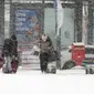 Orang-orang menuju ke stasiun bus di tengah hujan salju lebat di Gwangju, Korea Selatan, Selasa, 24 Januari 2023. Suhu ekstrem tidak hanya melanda Korea Selatan, tetapu juga negara Asia Timur lainnya, seperti Korea Utara, China, dan Jepang. (Chun Jung-in/Yonhap via AP)