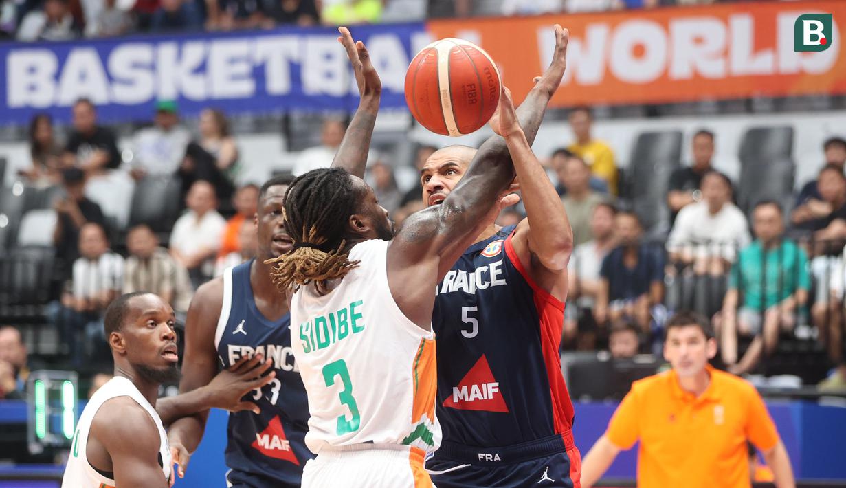 Pebasket Prancis, Nicolas Batum, diadang pebasket Pantai Gading, Amadou Sidibe pada laga FIBA World Cup 2023 di Indonesia Arena, Sabtu (2/9/2023). Prancis menang dengan skor 87-77. (Bola.com/M Iqbal Ichsan)