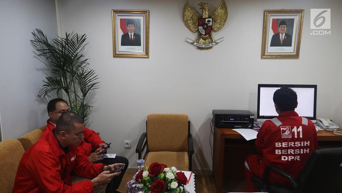 Calon legislatif dari Partai Solidaritas Indonesia (PSI) mendatangi gedung DPR RI di Senayan, Jakarta, Jumat (7/12). Kedatangan mereka untuk kampanye bersih-bersih DPR sambil mengenakan seragam merah ala cleaning service. (Liputan6.com/Johan Tallo)