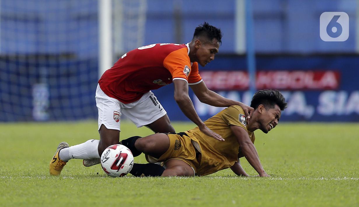 Pemain Borneo FC Samarinda Hendro Siswanto melanggar pemain Bhayangkara Solo FC Andik Vermansah dalam pertandingan babak penyisihan Piala Menpora 2021 di Stadion Kanjuruhan, Malang, Jawa Timur, Senin (22/3/2021). (Bola.com/Arief Bagus)