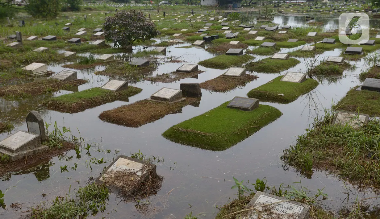 Banjir merendam sejumlah makam di Tempat Pemakaman Umum (TPU) Tanah Kusir, Jakarta, Jumat (3/1/2020). TPU Tanah Kusir terendam banjir setelah Kali Pesanggrahan meluap akibat intensitas hujan  yang tinggi pada Rabu lalu. (merdeka.com/Imam Buhori)