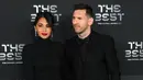 Pemain Paris Saint-Germain asal Argentina, Lionel Messi (kanan) dan istrinya Antonela Roccuzzo berpose setibanya pada acara The Best FIFA Football Awards 2022 di Paris, Prancis, 27 Februari 2023. Antonella pun terlihat makin cantik dengan riasan tipis disertai beberapa aksesoris mewah berwana perak. (FRANCK FIFE/AFP)